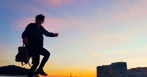 Silhouette man against sky during sunset