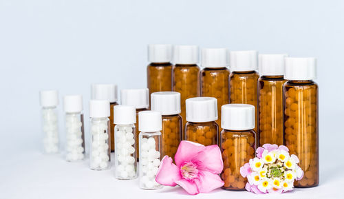 Close-up of medicines in bottle against white background