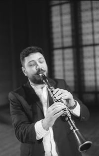 Man playing clarinet while standing at studio