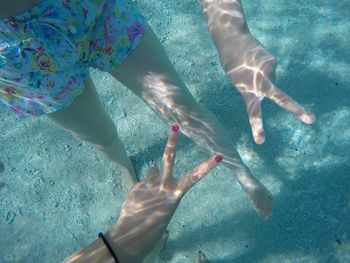 Women gesturing peace sign in sea