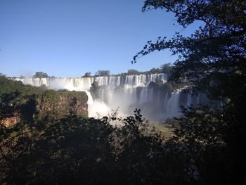 View of waterfall in forest against sky