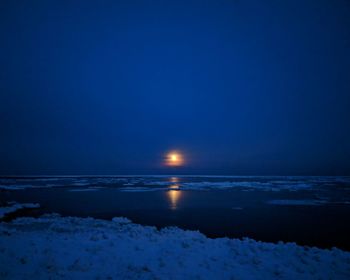 Scenic view of sea against clear sky at night