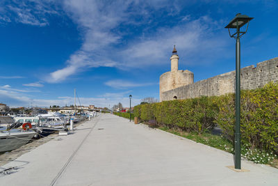 Street amidst buildings against blue sky