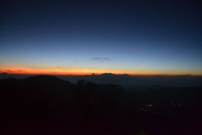 Scenic view of silhouette mountains against sky at sunset