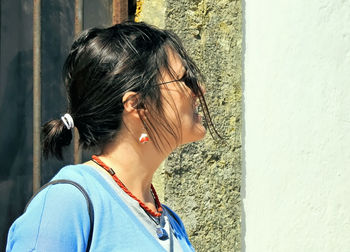 Close-up portrait of woman standing against wall