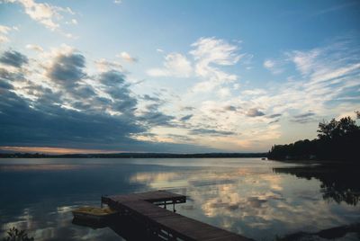 Boats in lake against cloudy sky