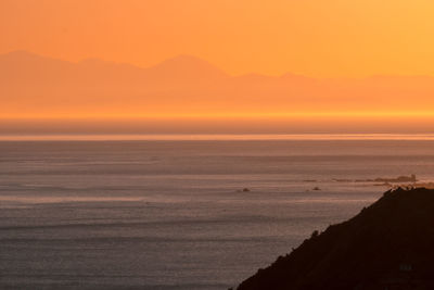 Scenic view of sea against orange sky