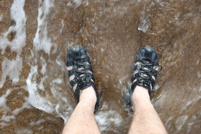 Low section of man standing in water