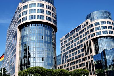 Low angle view of modern buildings against blue sky