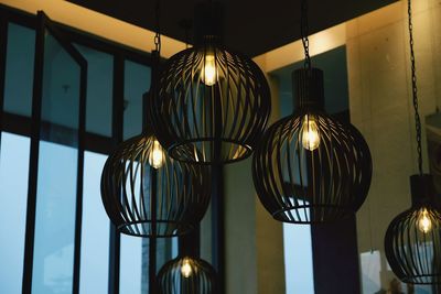 Low angle view of illuminated pendant light hanging from ceiling