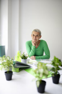 Side view of young woman sitting on table