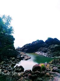 Scenic view of sea and mountains against clear sky