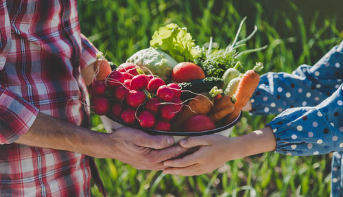 Midsection of woman holding fruit