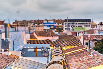 High angle view of buildings against cloudy sky