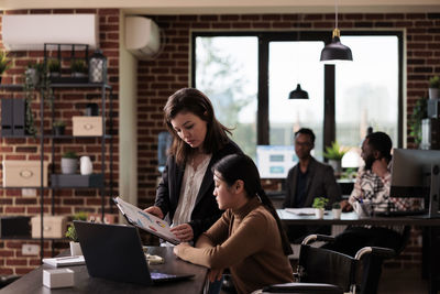 Businesswoman having discussion with colleague in office