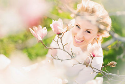 Portrait of young woman with pink flowers