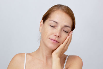 Close-up of young woman against white background