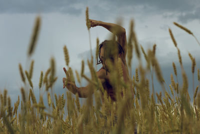 Shirtless young man gesturing while standing at farm