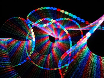 Close-up of illuminated lighting equipment against black background