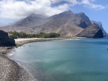 Scenic view of sea and mountains against sky