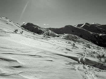 Low angle view of snowcapped mountains against sky on sunny day