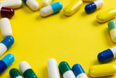 High angle view of medicines on yellow background