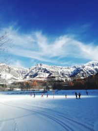 Group of people on snowcapped mountain against sky