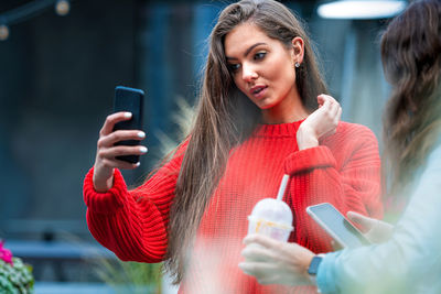 Young woman photographing with mobile phone