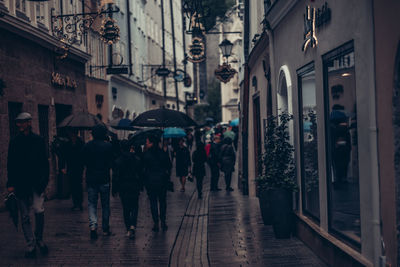 People walking on wet street in rainy season