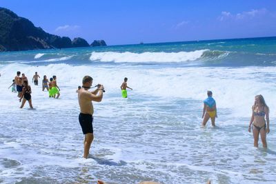 People standing on beach against sky