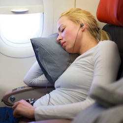 Side view of woman sleeping at airplane