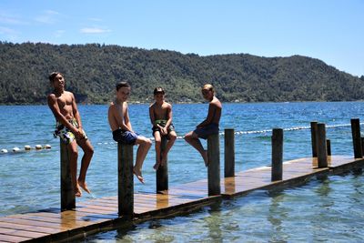 People standing on pier over sea against sky