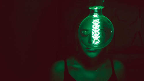 Close-up of illuminated light bulb against black background