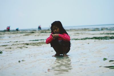 Full length of woman on beach against clear sky