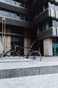 Bicycle on sidewalk by building in city