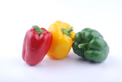 Close-up of multi colored bell peppers against white background