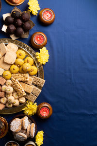 Indian traditional sweets laddu, soan papdi, burfi, gulab jamun for festival on blue background