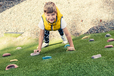 High angle portrait of boy climbing wall