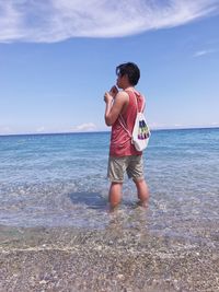 Full length of man standing on beach against sky