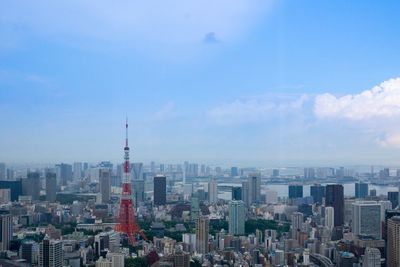 Tokyo tower amidst cityscape against sky