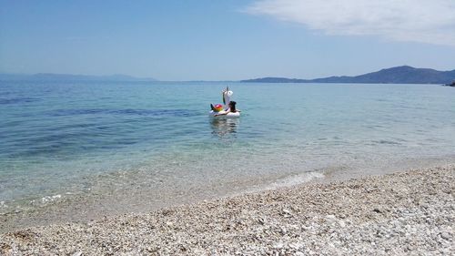 People on sea against sky