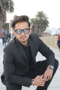 Portrait of young man crouching outdoors