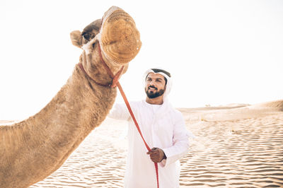 Man wearing hat on land against clear sky