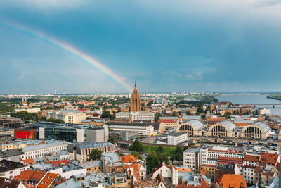 Rainbow over cityscape against sky