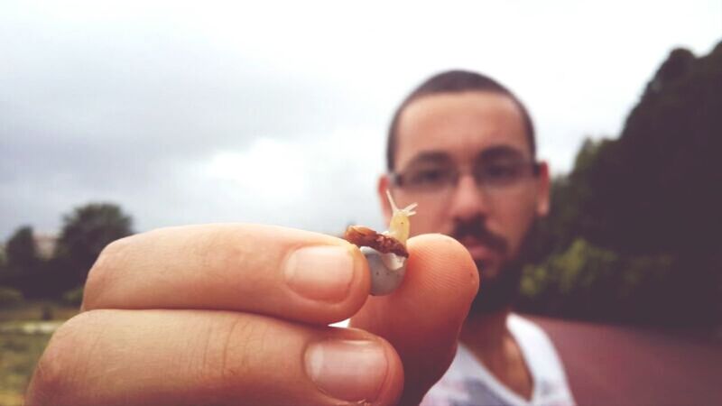 holding, focus on foreground, lifestyles, person, leisure activity, close-up, sky, headshot, human finger, outdoors, part of, day, cropped, waist up, nature, young adult