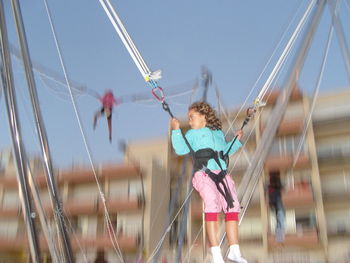 Low angle view of girl enjoying bungee trampoline