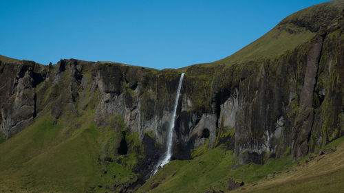 Scenic view of waterfall against sky