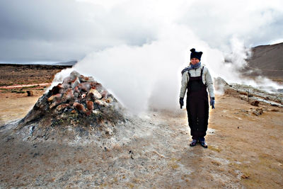 Rear view of man on mountain against sky