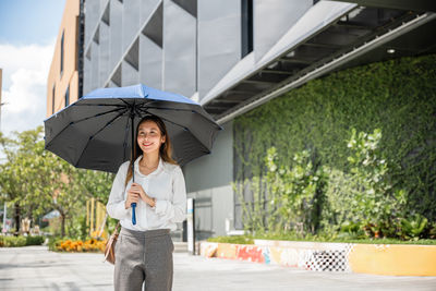 Rear view of woman holding umbrella