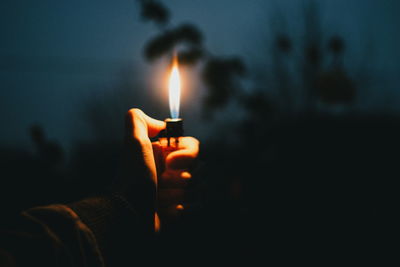 Close-up of hand holding illuminated cigarette lighter